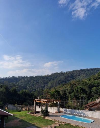 a swimming pool with a view of a mountain at Chalé Pedacinho do Céu in Mairiporã