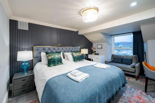 a bedroom with a large bed with two towels on it at Waterhead Rooms & Suites - Parking Available Onsite in Ambleside