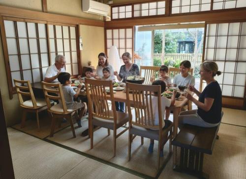 a group of people sitting around a dining room table at The house of calmness in Beppu