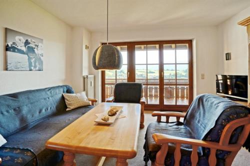 a living room with a blue couch and a table at StaigAllgäublick in Sonthofen