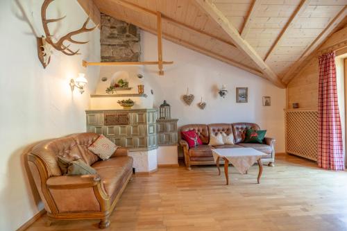 a living room with leather couches and a table at Landhaus Waibel in Blaichach