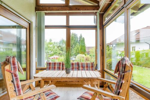 a screened in porch with a table and two chairs at Bergfink in Waltenhofen