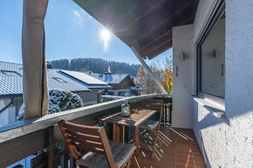 a balcony with a table and chairs on a roof at Fewo Blick in die Berge in Ofterschwang