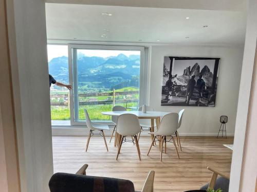 a dining room with a table and chairs and a window at Chalet 44 in Ofterschwang