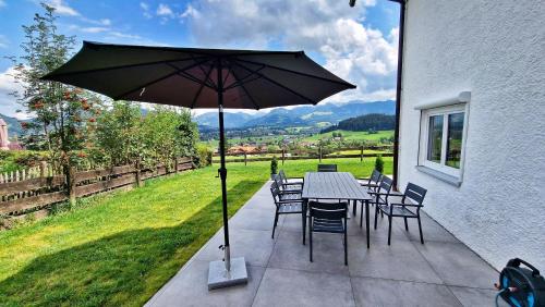 a table and chairs with an umbrella on a patio at Chalet 44 in Ofterschwang