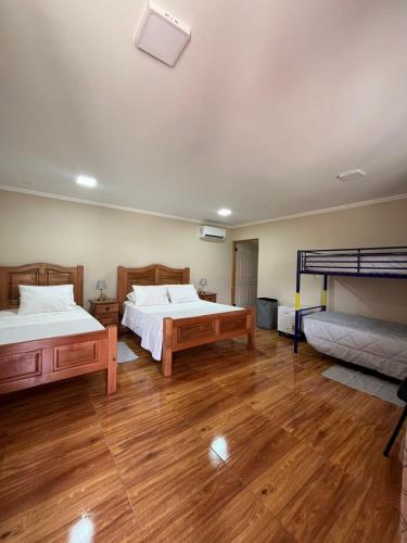 a bedroom with two beds and wooden floors at Hotel Parcela Tierra Fértil in Coltauco