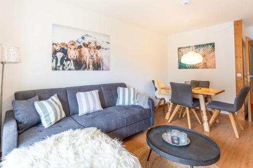 a living room with a couch and a table at Gipfelliebe in Bad Hindelang