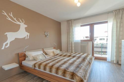 a bedroom with a bed with a deer stencil on the wall at Entschenkopf in Bolsterlang
