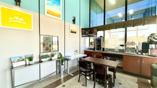 a restaurant with a table and chairs in a building at Days Inn by Wyndham Los Angeles LAX Airport Stadium Area in Los Angeles
