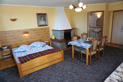 ヴィスワにあるDworek Sylwiaのベッドルーム1室(ベッド1台、テーブル、暖炉付)
