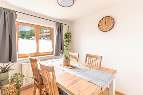 ein Esszimmer mit einem Tisch und einer Uhr an der Wand in der Unterkunft Stolz 2 in Blaichach