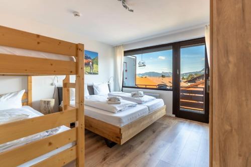 a bedroom with two bunk beds and a large window at Bergerwachen in Bolsterlang