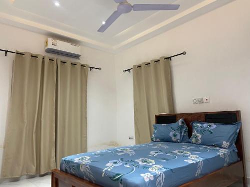 a bedroom with a bed with blue sheets and a ceiling at 2BR Ultra Modern Apartment in Gbawe in Gbawe