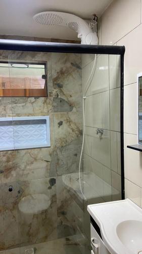 a bathroom with a shower and a sink at Chalé Dengo Dengo - Refúgio Romântico na Serra da Mantiqueira in Pindamonhangaba
