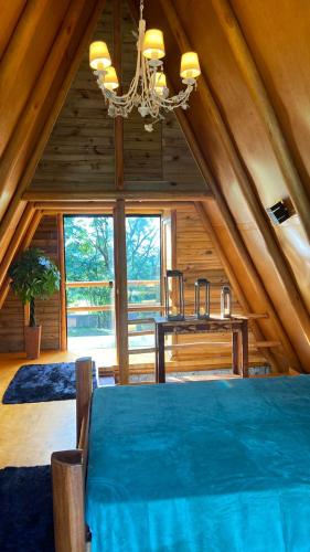 a room with a blue bed in a attic at Chalé Dengo Dengo - Refúgio Romântico na Serra da Mantiqueira in Pindamonhangaba