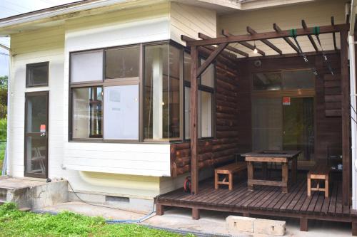a screened in porch of a house with a table on it at まるもりビレッジ in Wada