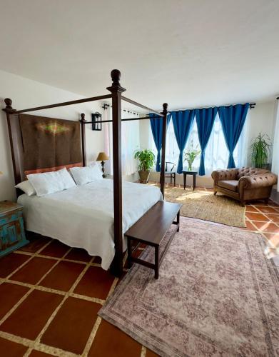 a bedroom with a large bed and a couch at Casa Lavanda in San Miguel de Allende
