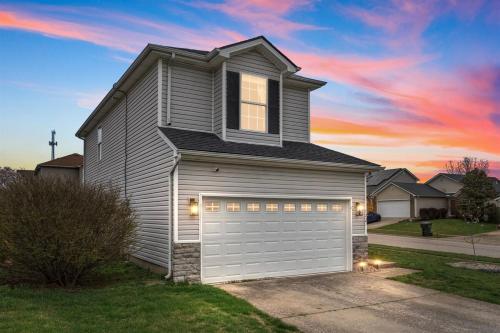 a house with a garage with a sunset at Spacious King Suite, Game Room, Patio, Firepit in Lexington