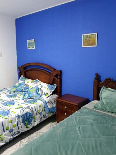 a bedroom with a bed and a blue wall at Van Gogh Duitama in Duitama