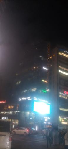 Dhaka Spa في داكا: مدينة ليلاً مع لافتة كبيرة أمام مبنى