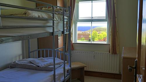 a room with two bunk beds and a window at SeaBreeze - Portballintrae in Portballintrae