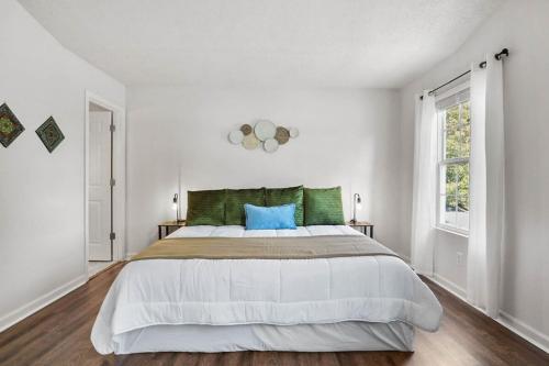 a white bedroom with a large bed with a blue pillow at Spacious King Suite, Horses, Fire Pit, Garage in Lexington