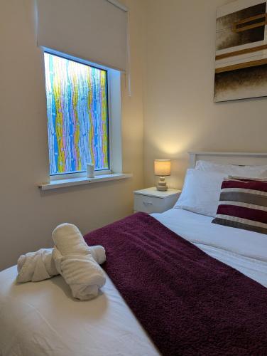 a bedroom with a bed with a stuffed animal on it at Entire 2 Bedroom Cosy Flat Near City Centre in Manchester