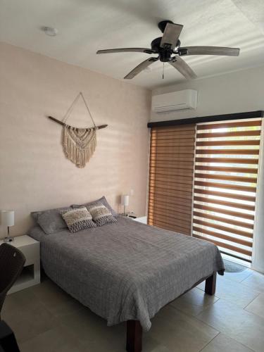 a bedroom with a bed and a ceiling fan at Habitat in Barra de Navidad