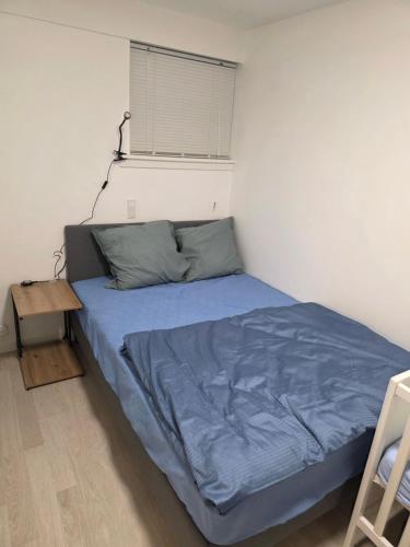 a bedroom with a bed with a blue comforter at 2 room apartment in Horsens in Horsens