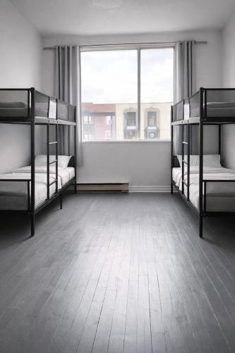 a room with three bunk beds and a window at Zen Hostel in Toronto