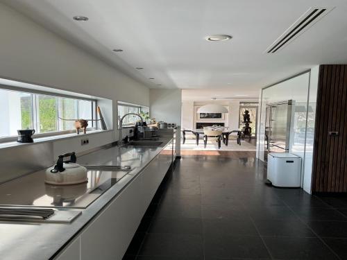 a kitchen with white countertops and a dining room at The Sweet Escape Premium villa with pool in Theux