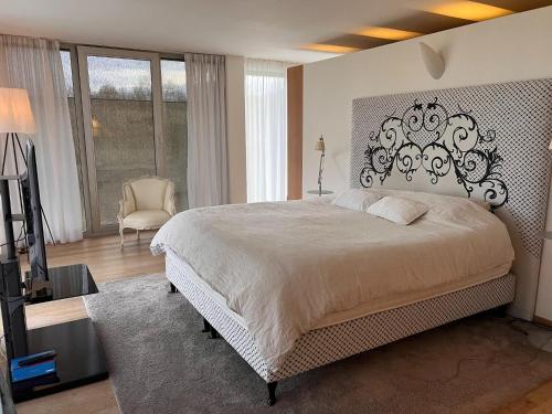 a bedroom with a large bed and a television at The Sweet Escape Premium villa with pool in Theux