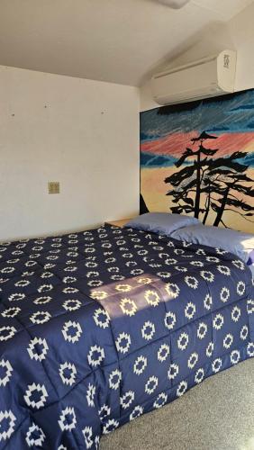 a bedroom with a bed with a blue and white blanket at Gerardín in Flagstaff