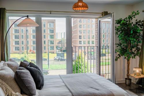 a bedroom with a bed and a large window at City Central - Free Private Parking, O2, University in Birmingham