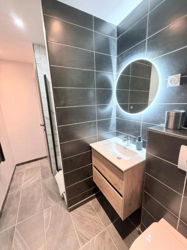 a bathroom with a sink and a mirror at loyika , résidence avec caméra et digicode possibilité location voiture Mercedes ,garage ,climatisation ,cheminée, Netflix, petit déjeuner , repas du soir fondue, raclette , barbecue sur demande in Albertville