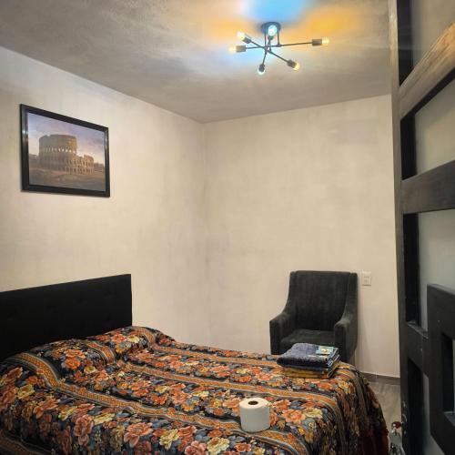 a bedroom with a bed and a chair at Hospedaje Don Juve in Atlixco