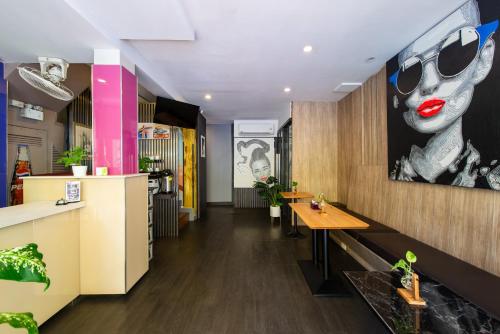 a restaurant with a table and a painting of a woman at BB House Phra Athit บีบี เฮ้าส์ พระอาทิตย์ in Bangkok