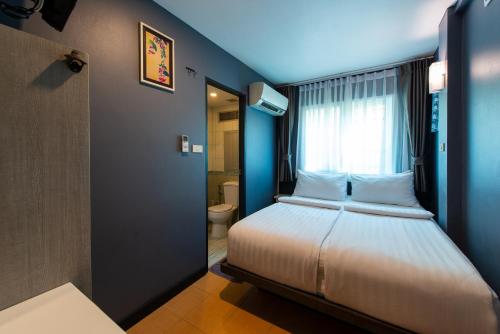 a bedroom with a bed with a window and a toilet at BB House Phra Athit บีบี เฮ้าส์ พระอาทิตย์ in Bangkok