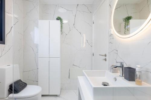 a white bathroom with a sink and a mirror at Luna do Mar - Luxury apt with Jacuzzi in Gaula