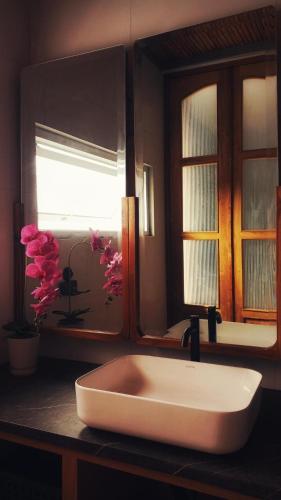 a white sink in a bathroom with a window at The Sawa Stay in Jarakan