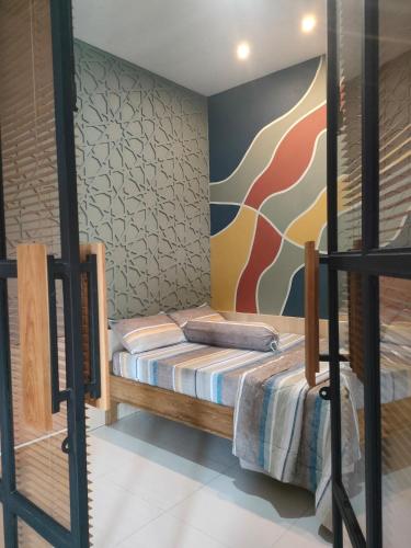 a bedroom with two bunk beds and a mural at The Sawa Stay in Jarakan