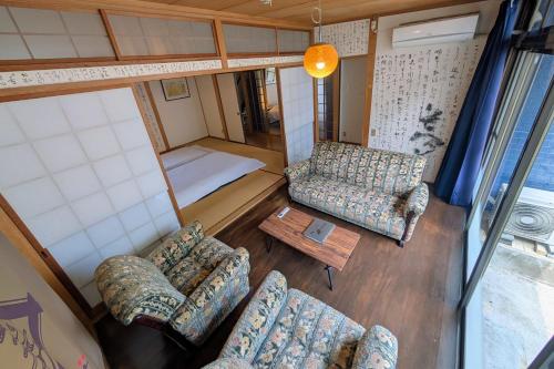 an aerial view of a living room with couches and a bed at 地獄の三丁目 鬼のすみか in Beppu