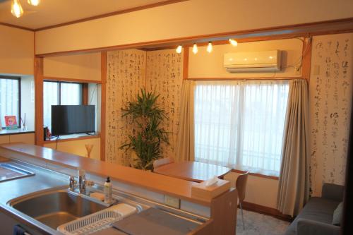 a kitchen with a sink and a living room at 地獄の三丁目 鬼のすみか in Beppu