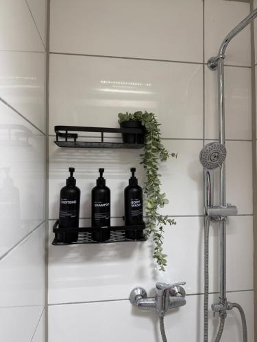 a bathroom sink with three black bottles on a shelf at Zentrale Gästezimmer am Marienplatz- Paris in Stuttgart