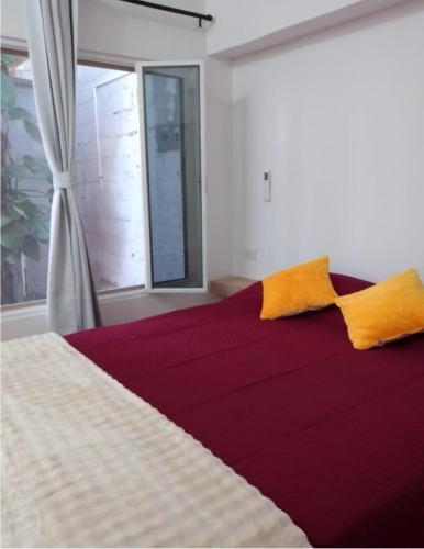a bedroom with a large bed with two yellow pillows at Casa Tamarindo in San Carlos