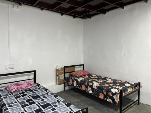 two beds sitting in a room with a roomthritisthritisthritisthritisthritisthritisthritis at Pushpa Nilayam in Khaprail