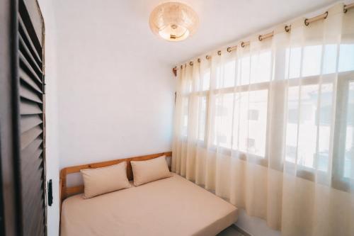 a bed sitting in a room with a window at Maluhia Home - Maio in Calheta Do Maio