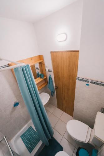 a bathroom with a shower curtain and a toilet at Maluhia Home - Maio in Calheta Do Maio