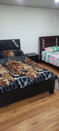 a bedroom with a bed with a cheetah blanket at Apto con balcon in Pasto