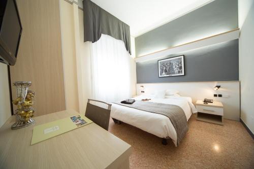 a hotel room with a bed and a table at Hotel Villa Igea Mhotelsgroup in Diano Marina